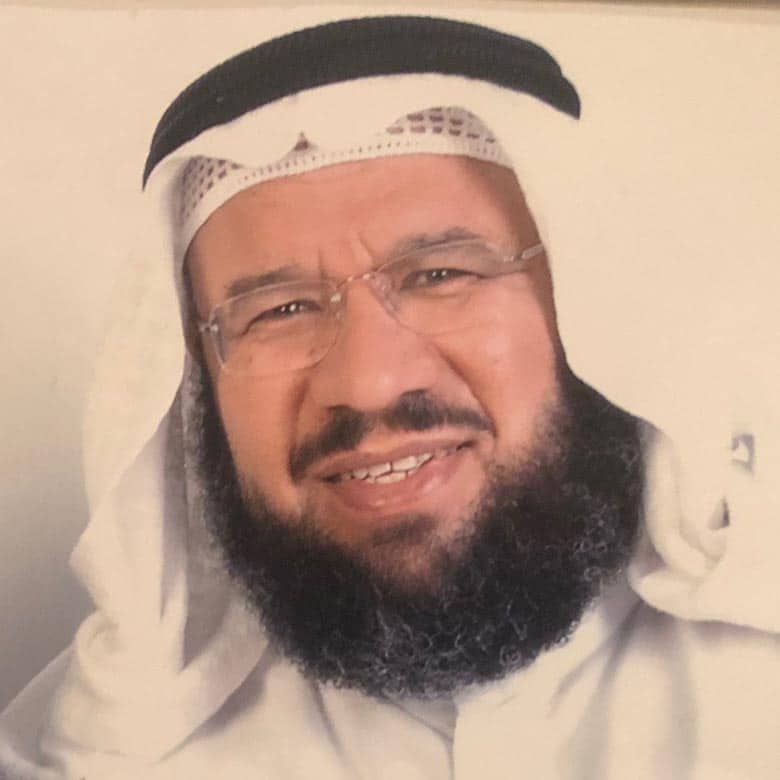 A man wearing traditional middle eastern attire, including a keffiyeh and agal, smiles warmly. his glasses and neatly trimmed beard suggest a composed demeanor.
